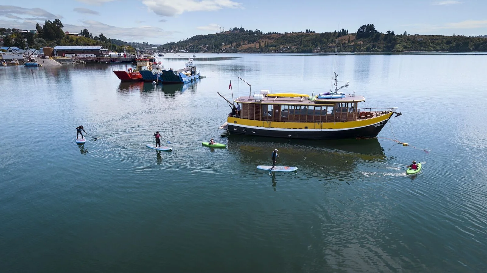 boat and paddleboarders near Refugia Chiloé
